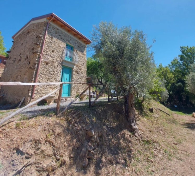 Antico rudere in pietra con porta turchese – Petra Sky Glamping Diamante